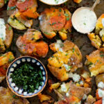 These Buffalo Smashed Potatoes are baked on a sheet pan until crispy, drizzled with buffalo sauce and served with vegan cilantro ranch | ThisSavoryVegan.com #thissavoryvegan #potatoreccipes #veganappetizers