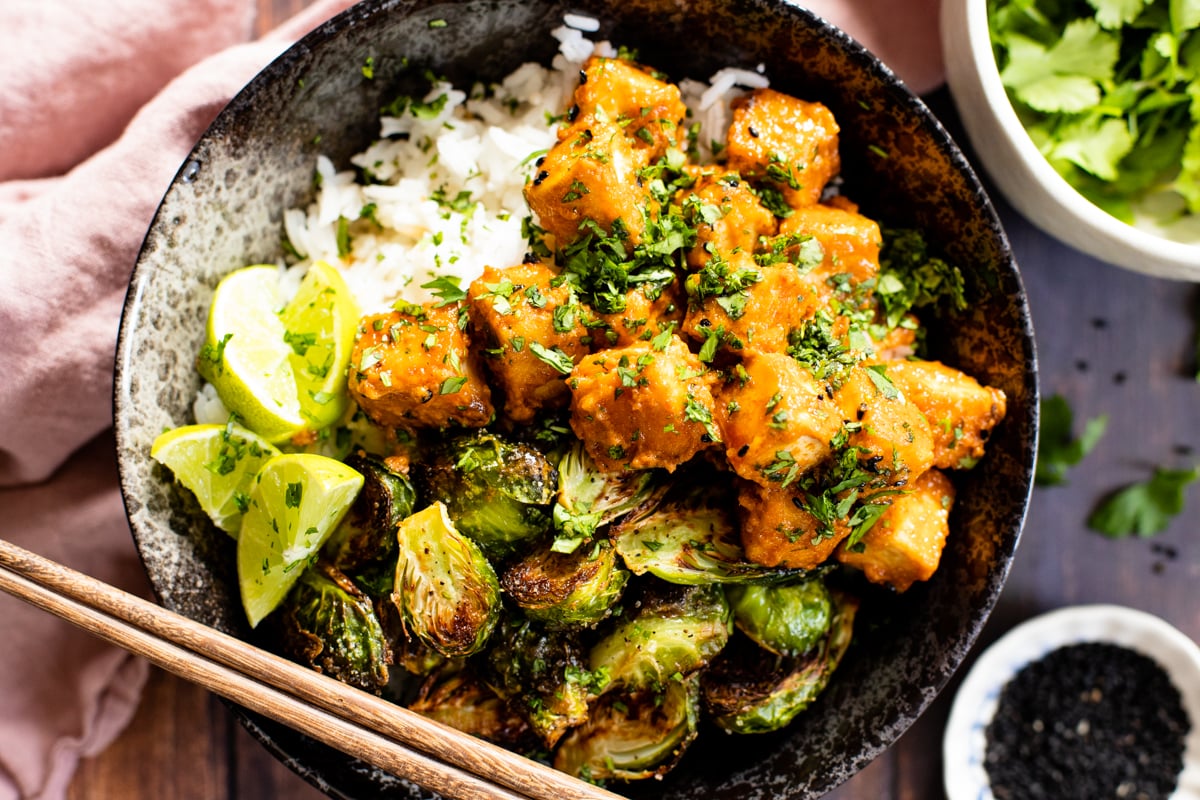 These Red Curry Tofu Bowls have a coconut red curry sauce, crispy tofu, roasted brussels sprouts and rice. An easy vegan dinner | ThisSavoryVegan.com #thissavoryvegan #tofurecipes #vegandinnerideas