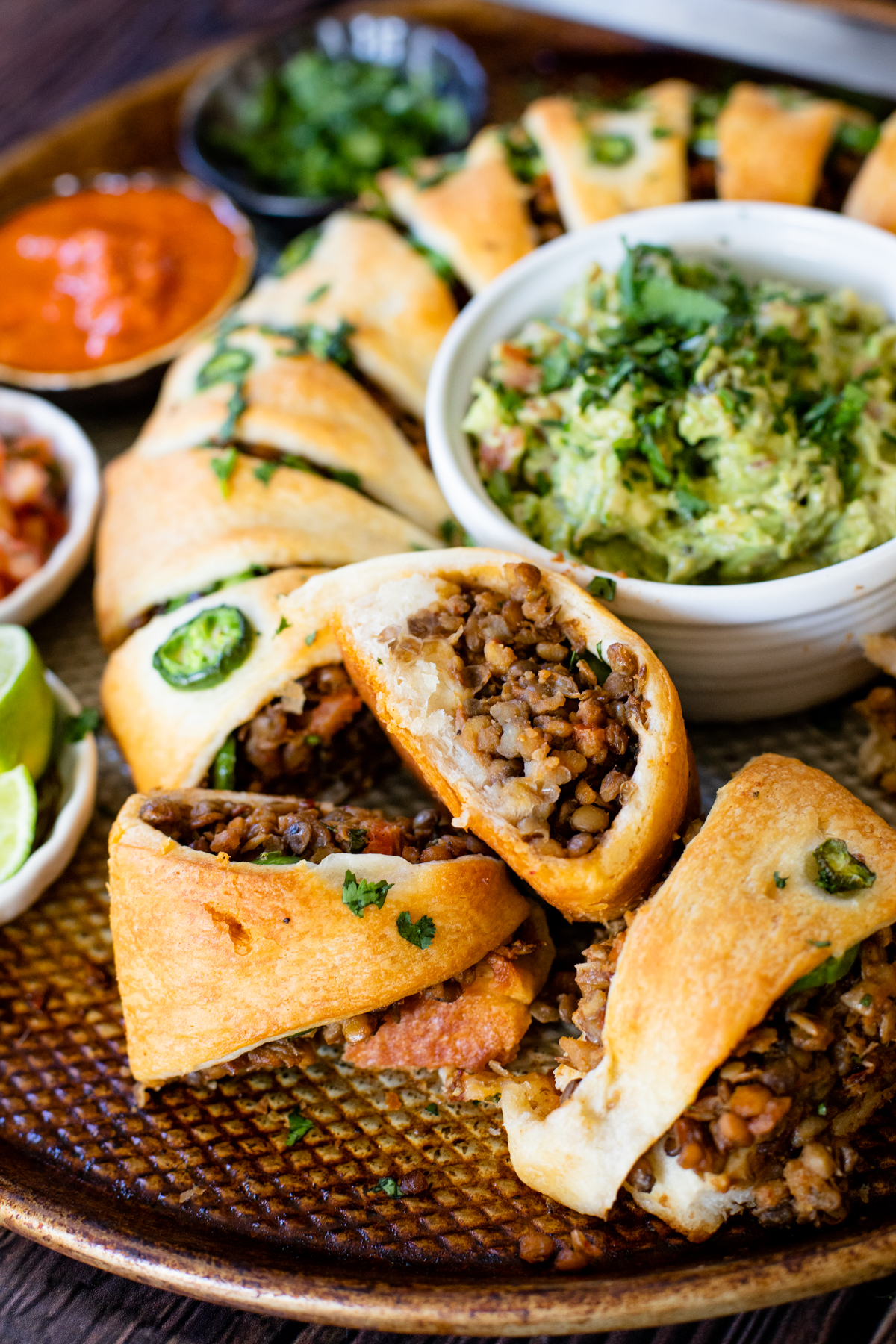 This Vegan Taco Crescent Ring is a fun party appetizer filled with chipotle lentils and served with guacamole, salsas & lime wedges | ThisSavoryVegan.com #thissavoryvegan #veganappetizers #veganpartyfood