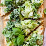 This Caesar Salad Pizza is the perfect combo - crispy pizza crust coated in vegan cream cheese and topped with the best dairy-free caesar salad | ThisSavoryVegan.com #thissavoryvegan #saladpizza #veganpizza