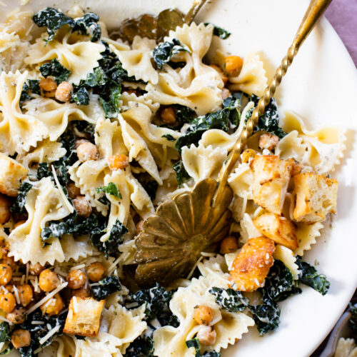 This Kale Caesar Pasta Salad is dairy-free and absolutely delicious! Fresh kale, chilled farfalle, vegan parmesan, roasted chickpeas, homemade ciabatta croutons & creamy caesar dressing | ThisSavoryVegan.com #thissavoryvegan #pastasalad #summerrecipes