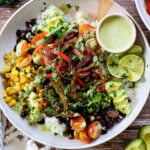 These Fajita Veggie Burrito Bowls have rice, beans, seasoned fajita veggies, corn, tomatoes, avocado & a non-dairy yogurt cilantro sauce | ThisSavoryVegan.com #thissavoryvegan #veganburritobowls #vegandinnerideas