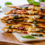 These Vegan Spinach & Feta Quesadillas are ready in 25 minutes & are filled with vegan feta, sun-dried tomatoes, shallots, cream cheese & spinach | ThisSavoryVegan.com #thissavoryvegan #veganquesadillas #vegansnacks