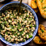 Chimichurri White Beans & Toast are filled with bright, fresh flavors. The garlic toast is the perfect dipper for these beans - served chilled or at room temperature | ThisSavoryVegan.com #thissavoryvegan #whitebeanrecipes #vegansidedish