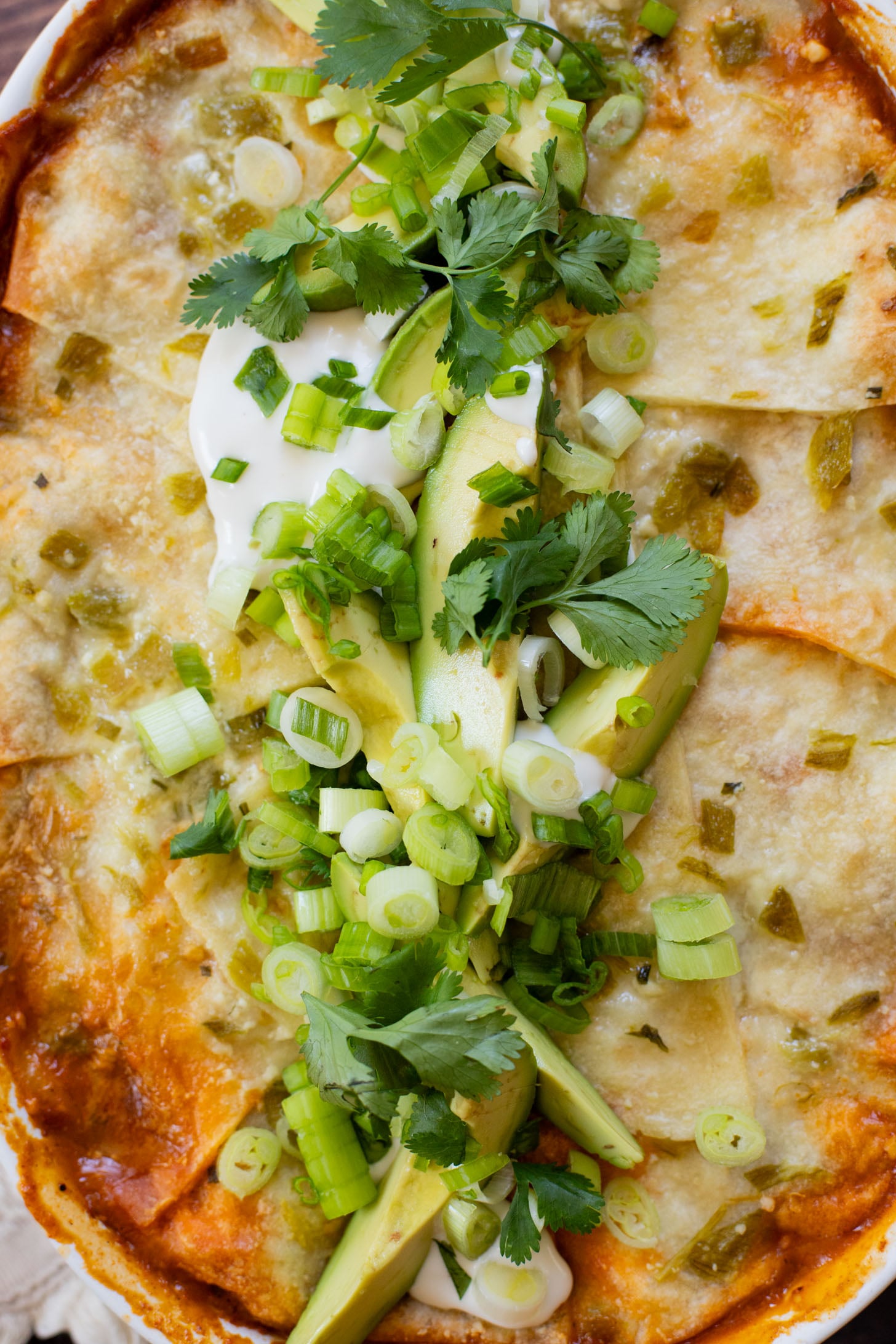 This vegan Green Chile Enchilada Casserole is made with a dairy-free sour cream sauce, lots of veggies, soyrizo, beans and flour tortillas | ThisSavoryVegan.com #thissavoryvegan #veganenchiladas #dairyfreeenchiladas