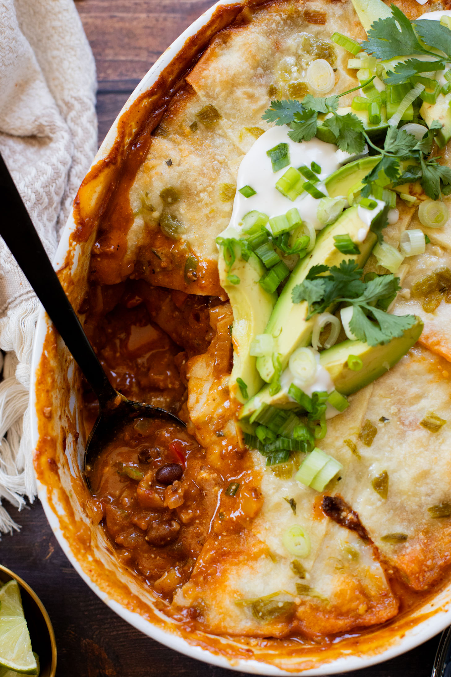 This vegan Green Chile Enchilada Casserole is made with a dairy-free sour cream sauce, lots of veggies, soyrizo, beans and flour tortillas | ThisSavoryVegan.com #thissavoryvegan #veganenchiladas #dairyfreeenchiladas