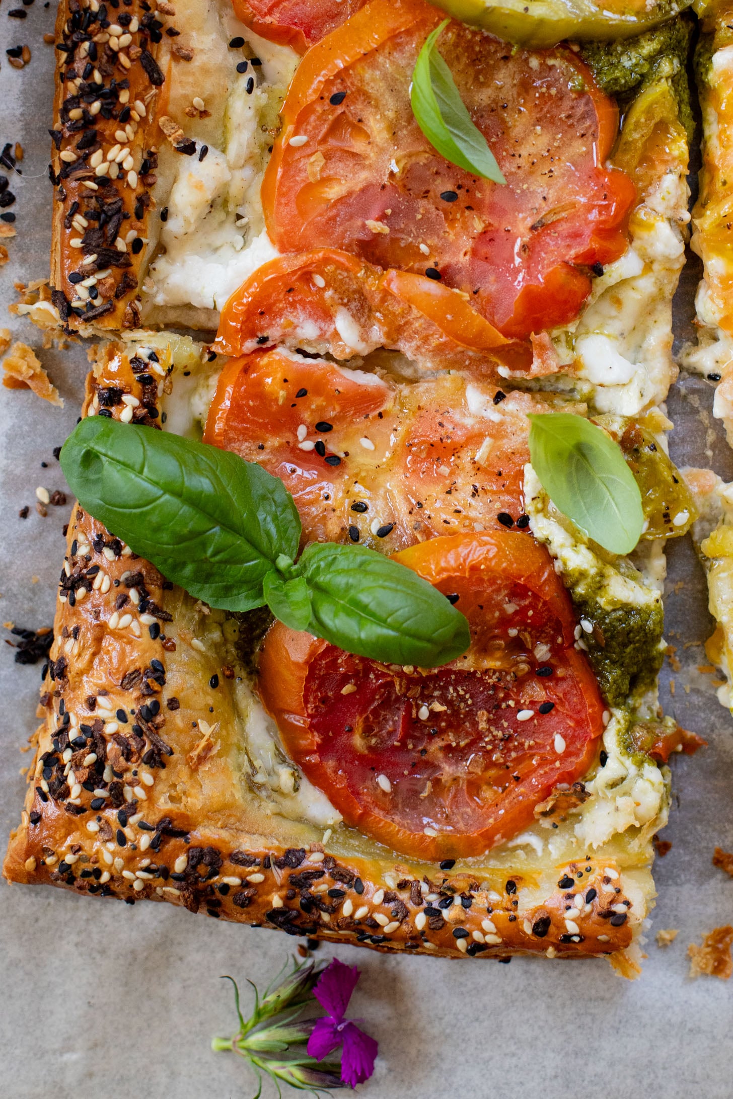 This vegan Heirloom Tomato Tart is made with puff pastry, a creamy non-dairy cheese, pesto & heirloom tomato slices. The perfect summer appetizer or brunch idea | ThisSavoryVegan.com #puffpastryideas #heirloomtomatorecipes #summerrecipes