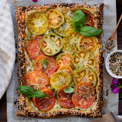 This vegan Heirloom Tomato Tart is made with puff pastry, a creamy non-dairy cheese, pesto & heirloom tomato slices. The perfect summer appetizer or brunch idea | ThisSavoryVegan.com #puffpastryideas #heirloomtomatorecipes #summerrecipes