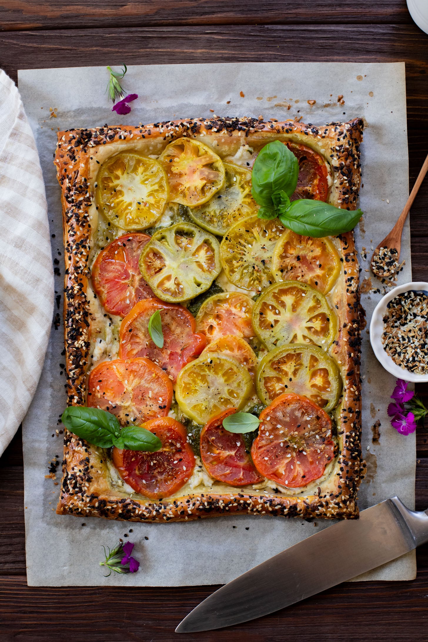 This vegan Heirloom Tomato Tart is made with puff pastry, a creamy non-dairy cheese, pesto & heirloom tomato slices. The perfect summer appetizer or brunch idea | ThisSavoryVegan.com #puffpastryideas #heirloomtomatorecipes #summerrecipes