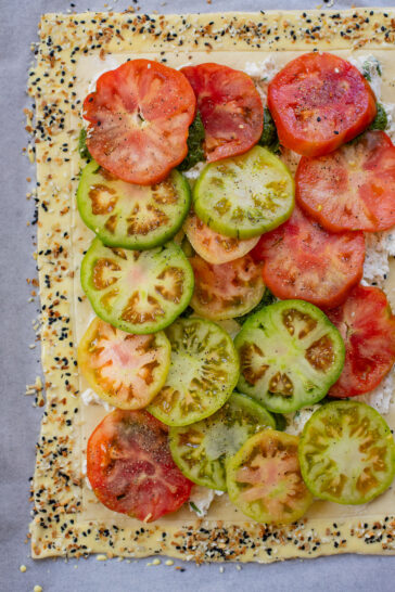 This vegan Heirloom Tomato Tart is made with puff pastry, a creamy non-dairy cheese, pesto & heirloom tomato slices. The perfect summer appetizer or brunch idea | ThisSavoryVegan.com #puffpastryideas #heirloomtomatorecipes #summerrecipes