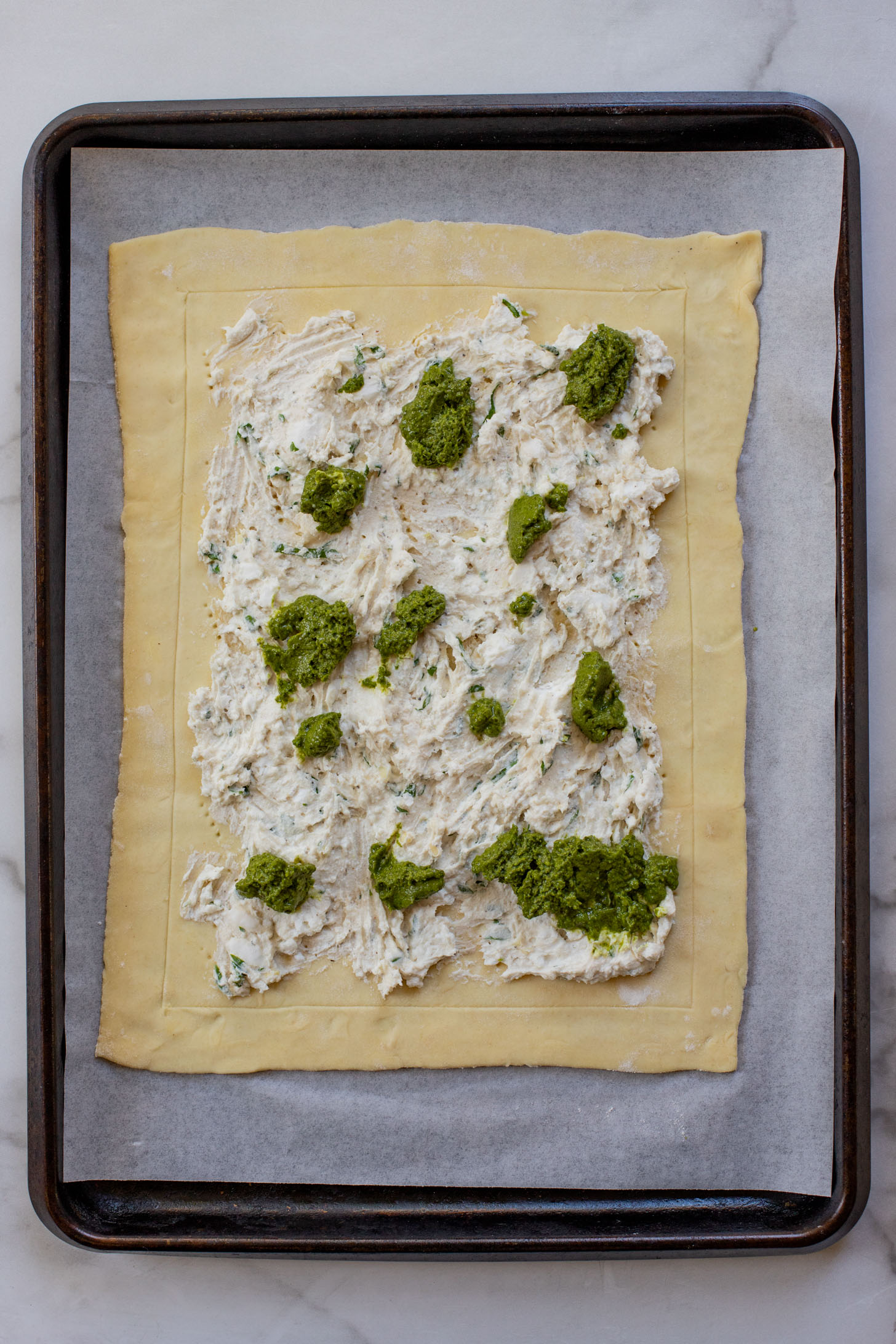 This vegan Heirloom Tomato Tart is made with puff pastry, a creamy non-dairy cheese, pesto & heirloom tomato slices. The perfect summer appetizer or brunch idea | ThisSavoryVegan.com #puffpastryideas #heirloomtomatorecipes #summerrecipes
