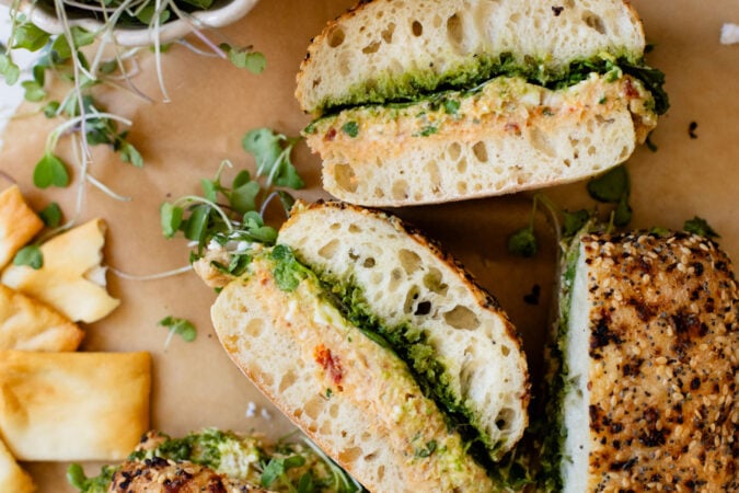 These Mediterranean Chickpea Salad Sandwiches are layered with vegan pesto, smashed chickpea salad, vegan feta and greens. The perfect vegan lunch | ThisSavoryVegan.com #vegansandwich #chickpearecipes #summerrecipes