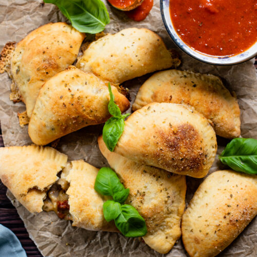 These Mediterranean Pizza Pockets are filled with vegan feta, vegan parmesan, sun-dried tomatoes, herbs & garlic. The perfect vegan snack or kid-friendly dinner | ThisSavoryVegan.com #thissavoryvegan #homemadepizzapockets #veganpizza