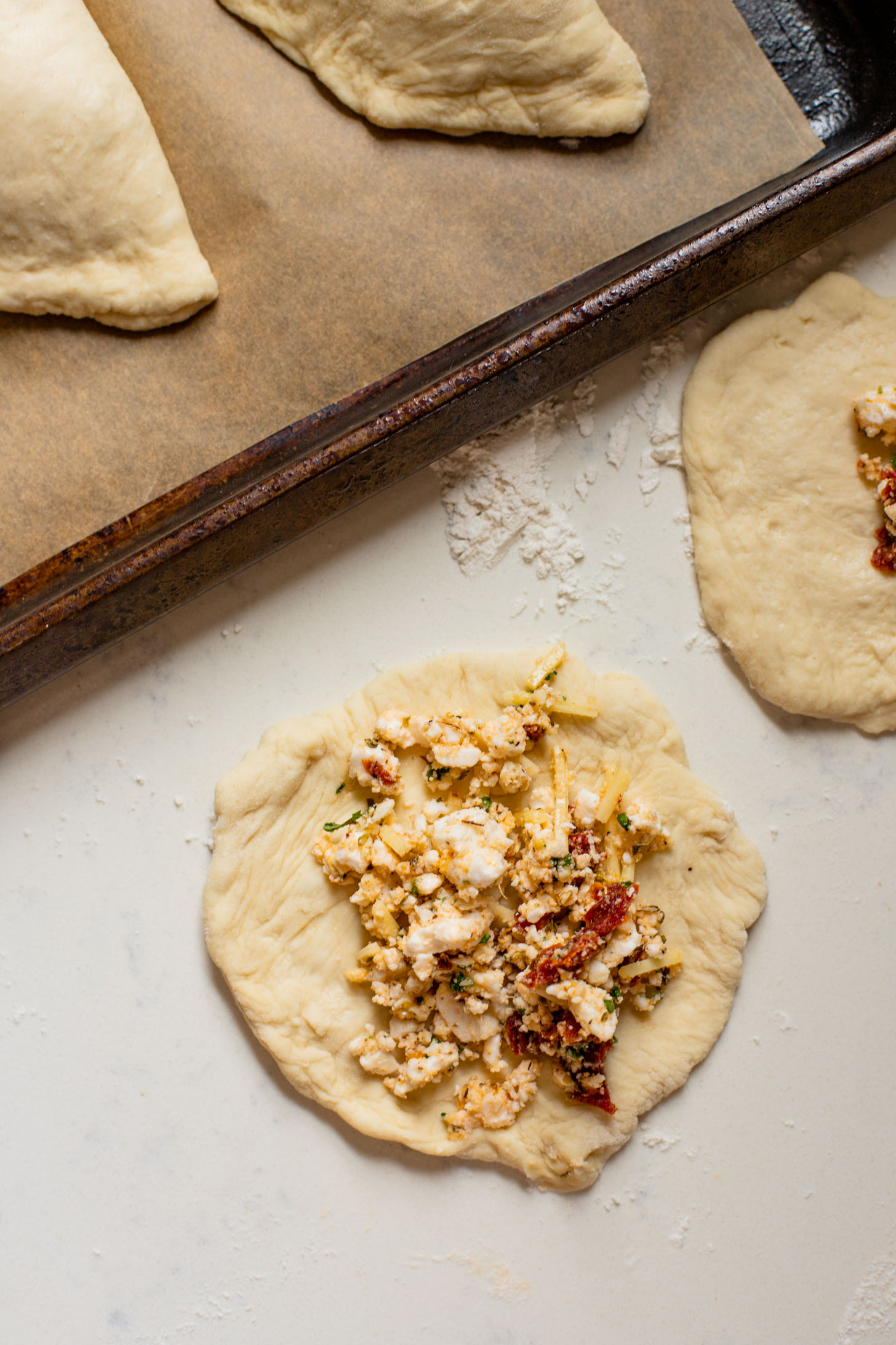 These Mediterranean Pizza Pockets are filled with vegan feta, vegan parmesan, sun-dried tomatoes, herbs & garlic. The perfect vegan snack or kid-friendly dinner | ThisSavoryVegan.com #thissavoryvegan #homemadepizzapockets #veganpizza