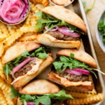 These Vegan Greek Sliders are made with impossible meat and are topped with a spicy aioli, pickled onions & arugula. The best vegan burger | ThisSavoryVegan.com #veganburgers #impossibleburgers #burgerrecipes