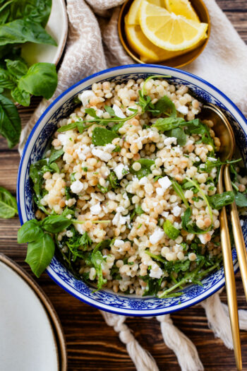 This Lemon Arugula Couscous Salad is a simple vegan salad that packs a ton of flavor! Made with pearl couscous and vegan feta. The perfect bite | ThisSavoryVegan.com #thissavoryvegan #summersalad #veganlunchideas