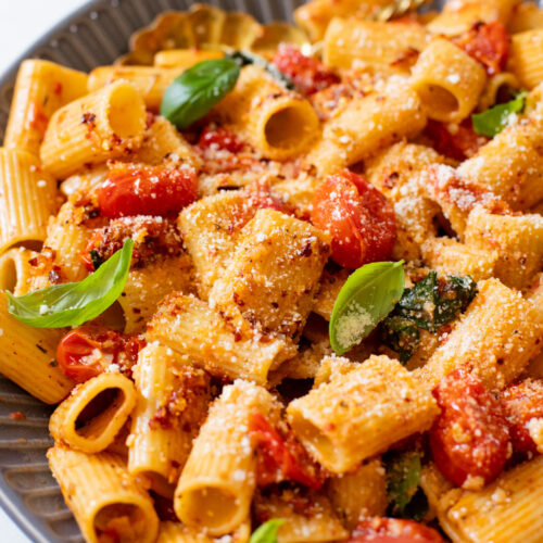This Spicy Burst Tomato Pasta is a simple vegan pasta recipe made with cherry tomatoes, lots of garlic & basil and chili crisp oil for some heat | ThisSavoryVegan.com #thissavoryvegan #veganpasta #spicypasta