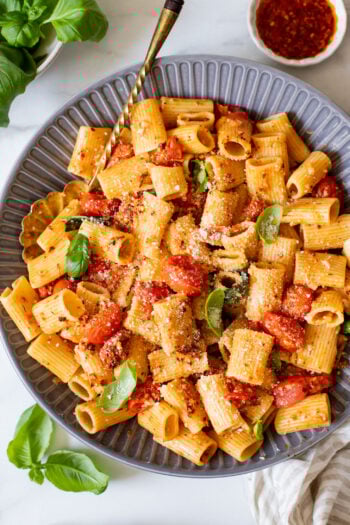 This Spicy Burst Tomato Pasta is a simple vegan pasta recipe made with cherry tomatoes, lots of garlic & basil and chili crisp oil for some heat | ThisSavoryVegan.com #thissavoryvegan #veganpasta #spicypasta