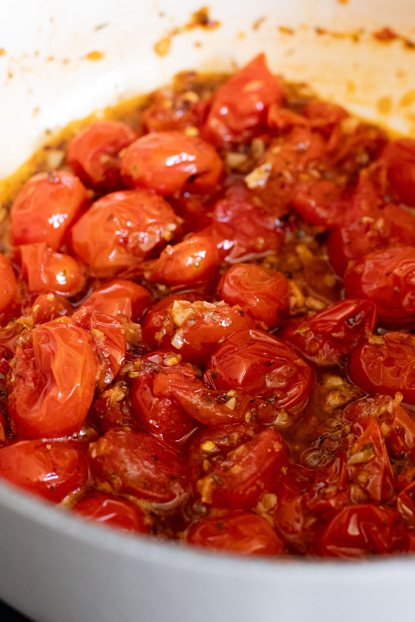 This Spicy Burst Tomato Pasta is a simple vegan pasta recipe made with cherry tomatoes, lots of garlic & basil and chili crisp oil for some heat | ThisSavoryVegan.com #thissavoryvegan #veganpasta #spicypasta