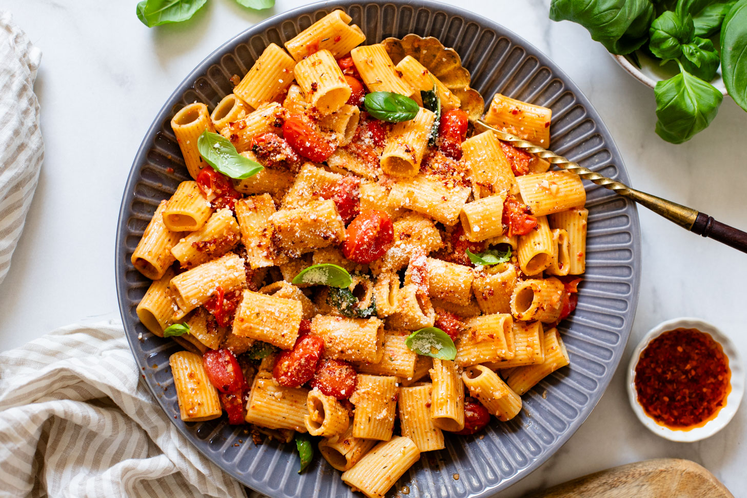 This Spicy Burst Tomato Pasta is a simple vegan pasta recipe made with cherry tomatoes, lots of garlic & basil and chili crisp oil for some heat | ThisSavoryVegan.com #thissavoryvegan #veganpasta #spicypasta