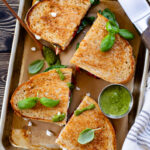 These Vegan Feta Grilled Cheese sandwiches are layered with vegan feta, pesto, spinach & roasted red peppers. Grilled until crispy and served hot | ThisSavoryVegan.com #vegansandwich #vegangilledcheese #vegancomfortfood