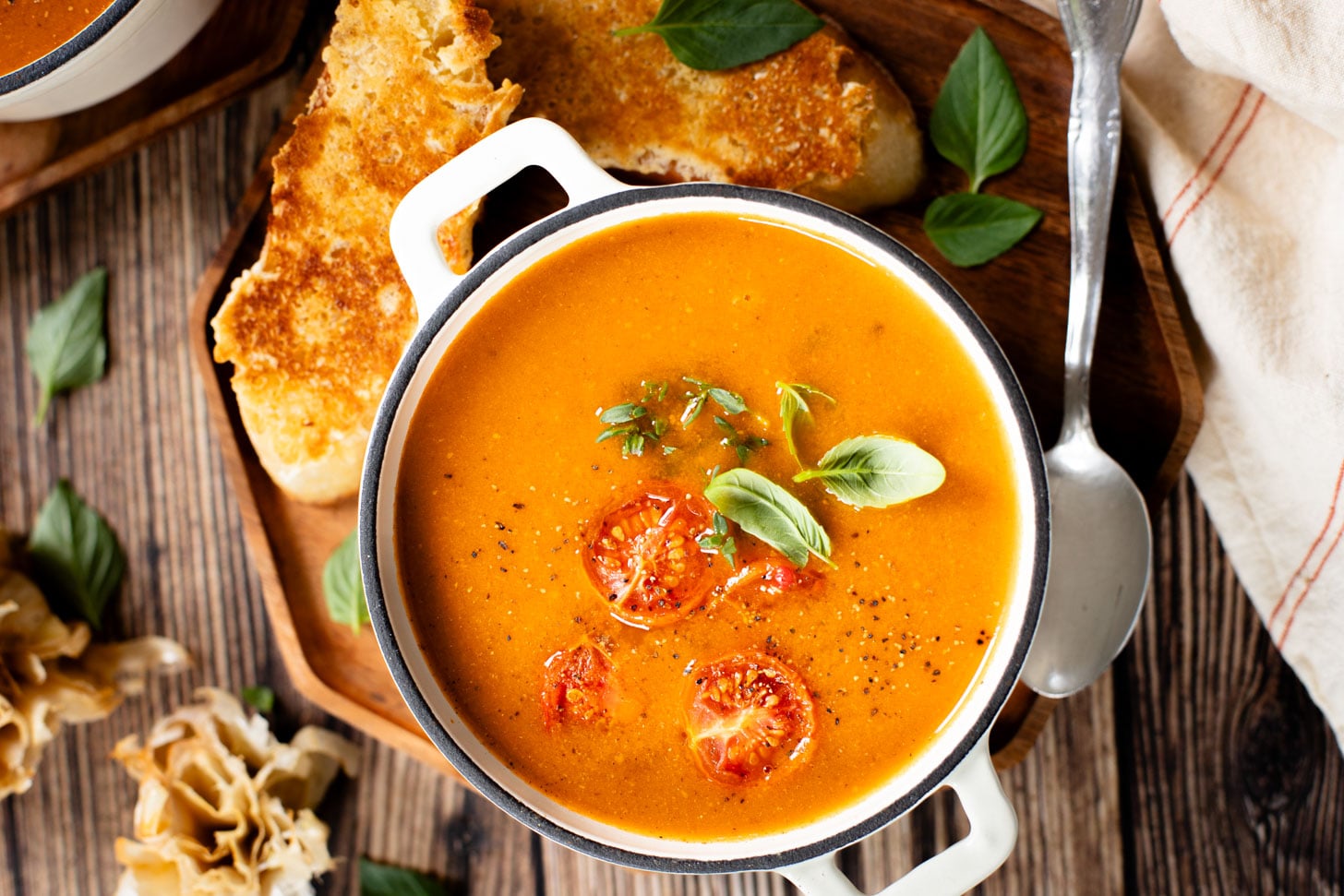 This Roasted Garlic Tomato Soup is creamy, savory & delicious. Served with vegan parmesan toast and topped with fresh basil | ThisSavoryVegan.com #tomatosoup #soupseason #vegansoup
