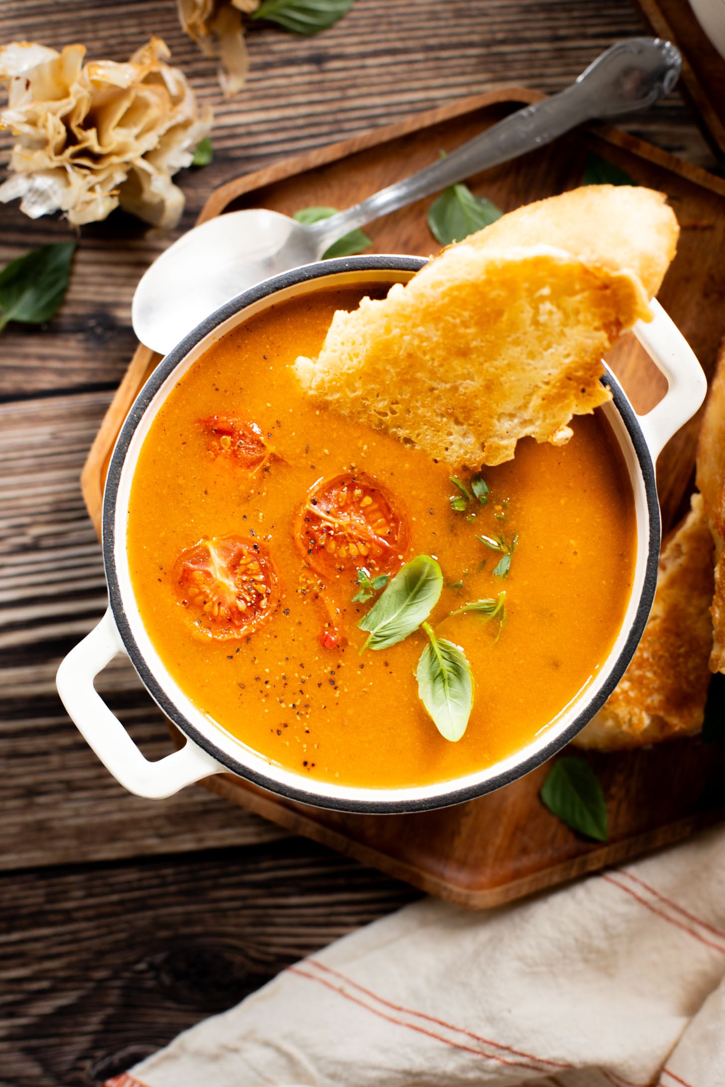 This Roasted Garlic Tomato Soup is creamy, savory & delicious. Served with vegan parmesan toast and topped with fresh basil | ThisSavoryVegan.com #tomatosoup #soupseason #vegansoup