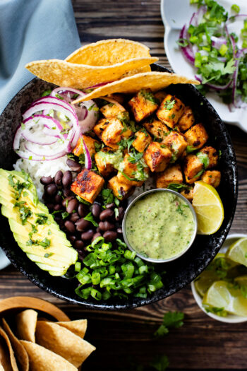 These Chipotle Tofu Burrito Bowls are filled with crispy baked tofu, black beans, rice, veggies and a super delicious cilantro yogurt sauce | ThisSavoryVegan.com #thissavoryvegan #burritobowls #tofurecipes