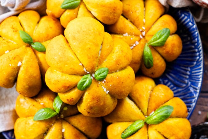 These Pumpkin Shaped Pizza Bites are stuffed with a mediterranean, dairy-free filling that is delicious! The perfect vegan fall recipe | ThisSavoryVegan.com #halloweenrecipes #thanksgivingrecipes #thanksgivingappetizers