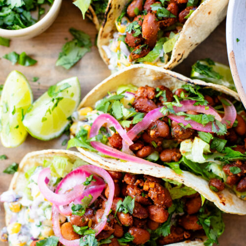 These Corn Salad & Bean Tacos are simple, vegan & delicious. Ready in 30 minutes and served with a Mexican corn salad, beans & pickled onions | ThisSavoryVegan.com #thissavoryvegan #vegantacos #beantacos