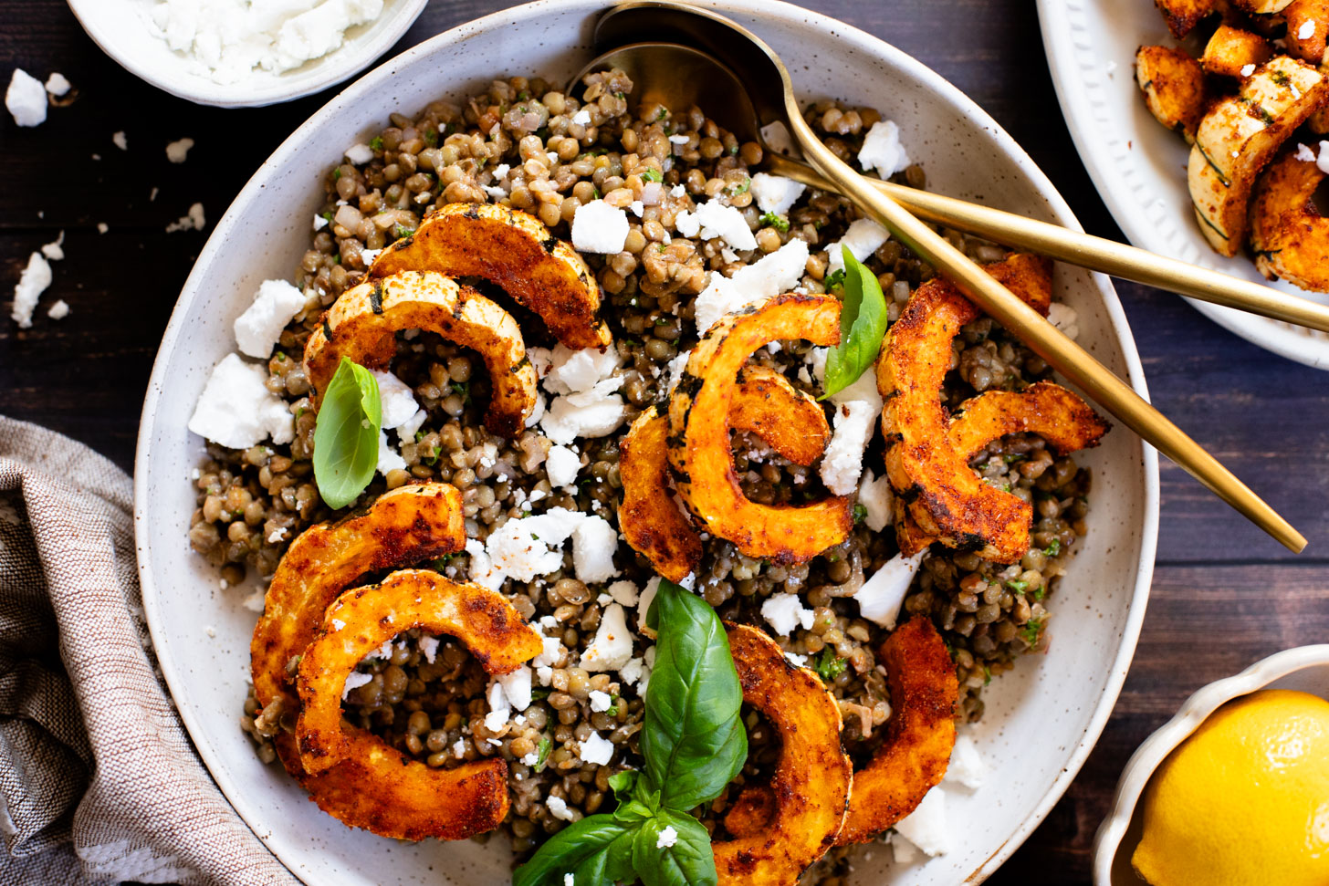 This Roasted Squash & Lentils recipe is a mix between a salad and a bowl. Crispy delicata squash, vegan feta and lemony lentils with fresh herbs | ThisSavoryVegan.com #thissavoryvegan #squashrecipes #fallrecipes