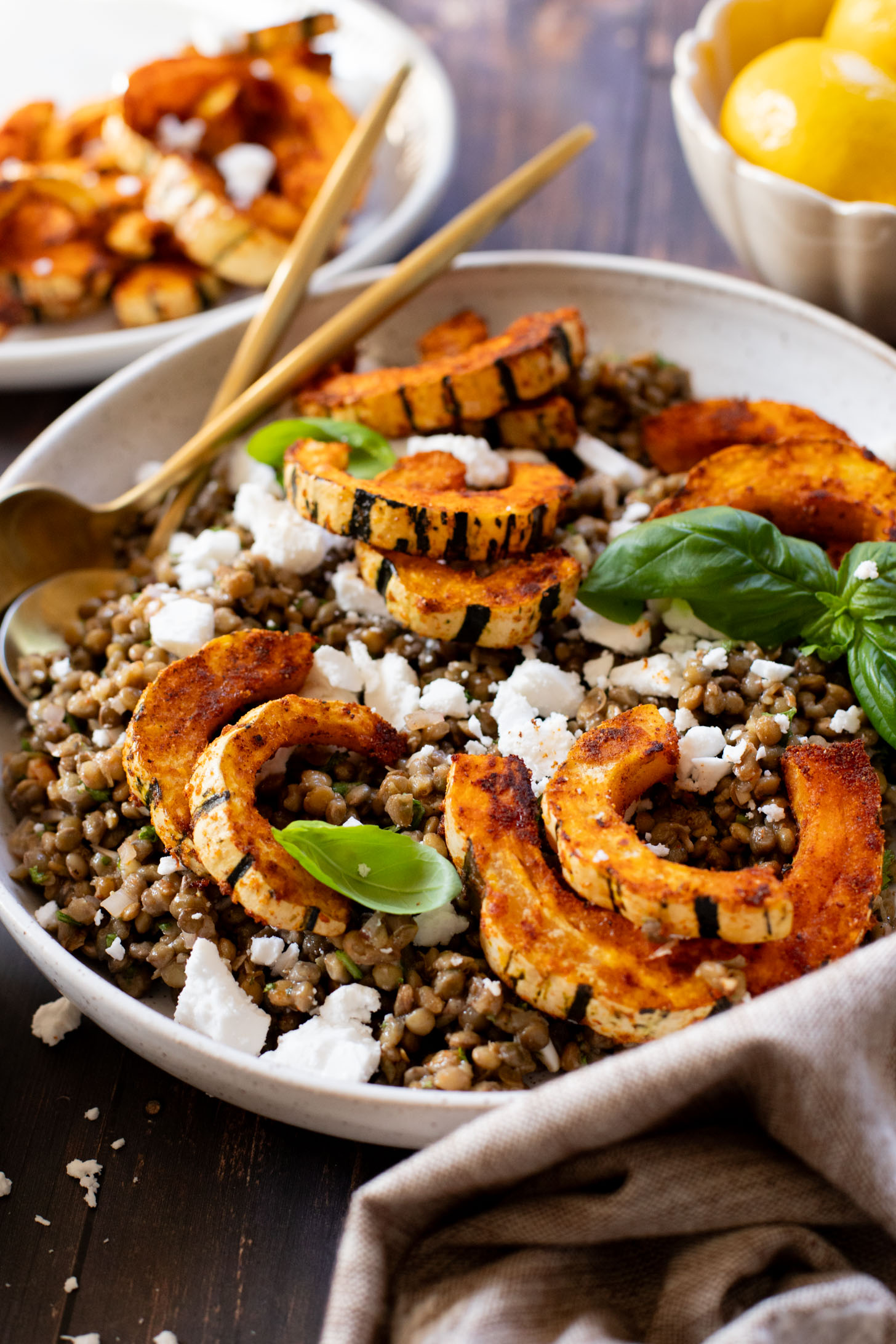 This Roasted Squash & Lentils recipe is a mix between a salad and a bowl. Crispy delicata squash, vegan feta and lemony lentils with fresh herbs | ThisSavoryVegan.com #thissavoryvegan #squashrecipes #fallrecipes