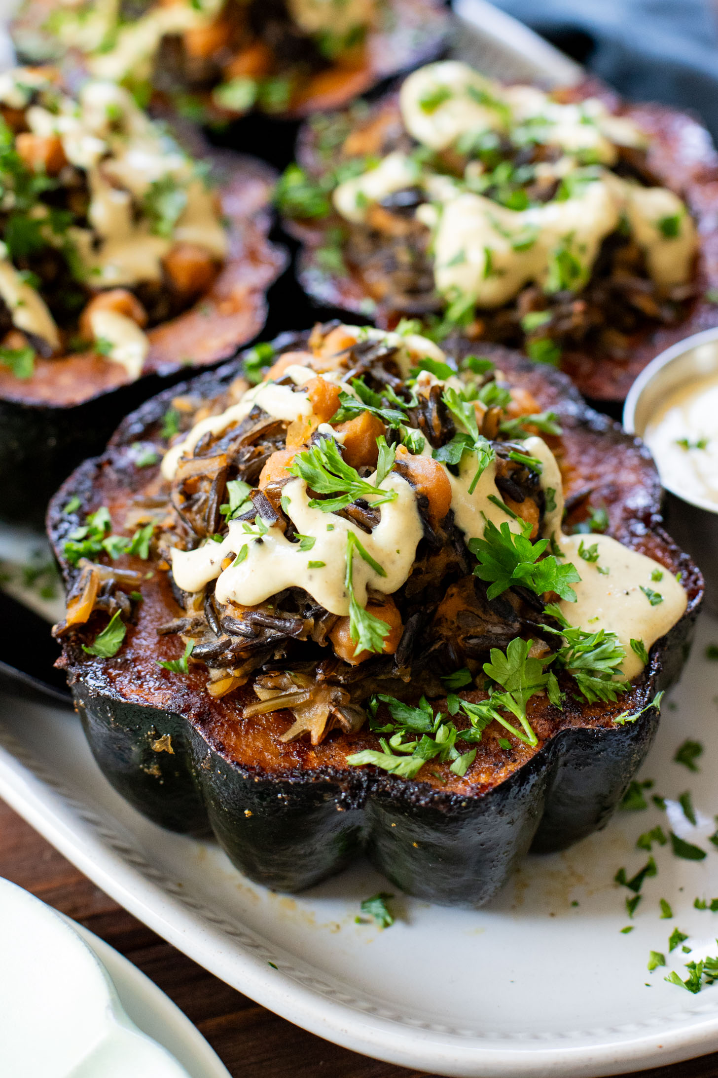 This Wild Rice Stuffed Acorn Squash recipe is filled with fall flavors. The squash is roasted until tender and stuffed with wild rice & chickpeas | ThisSavoryVegan.com #fallrecipes #wildricerecipes #falldinnerideas