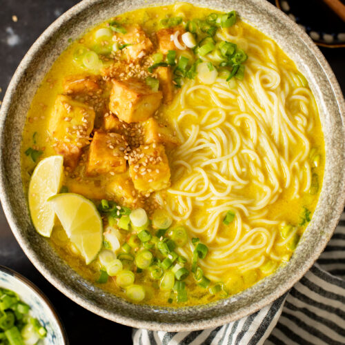 This Golden Coconut Noodle Soup is healthy & heart warming. A coconut curry broth, crispy baked tofu & tender rice noodles | ThisSavoryVegan.com #vegansoup #noodlesoup #healthysoup