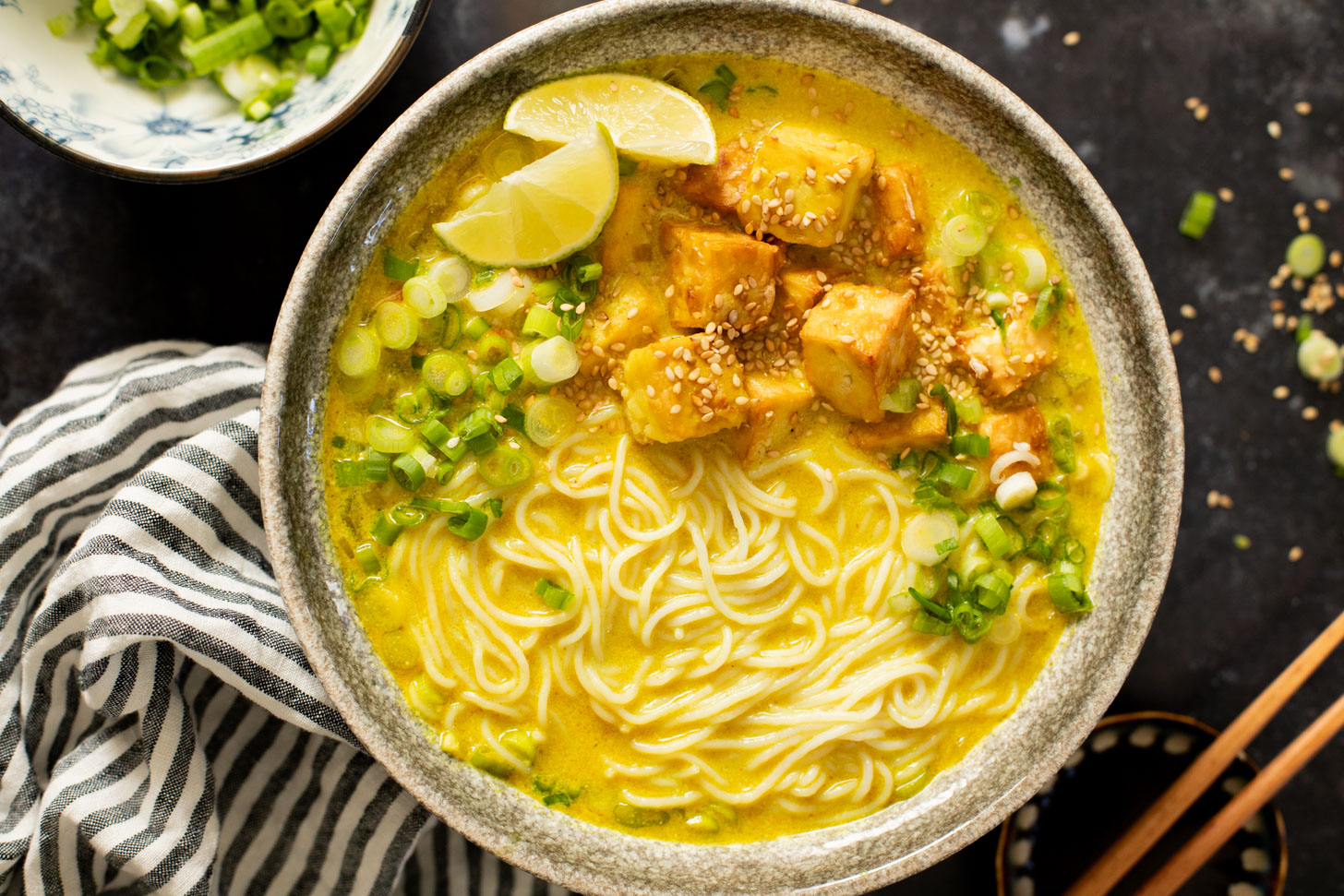 This Golden Coconut Noodle Soup is healthy & heart warming. A coconut curry broth, crispy baked tofu & tender rice noodles | ThisSavoryVegan.com #vegansoup #noodlesoup #healthysoup