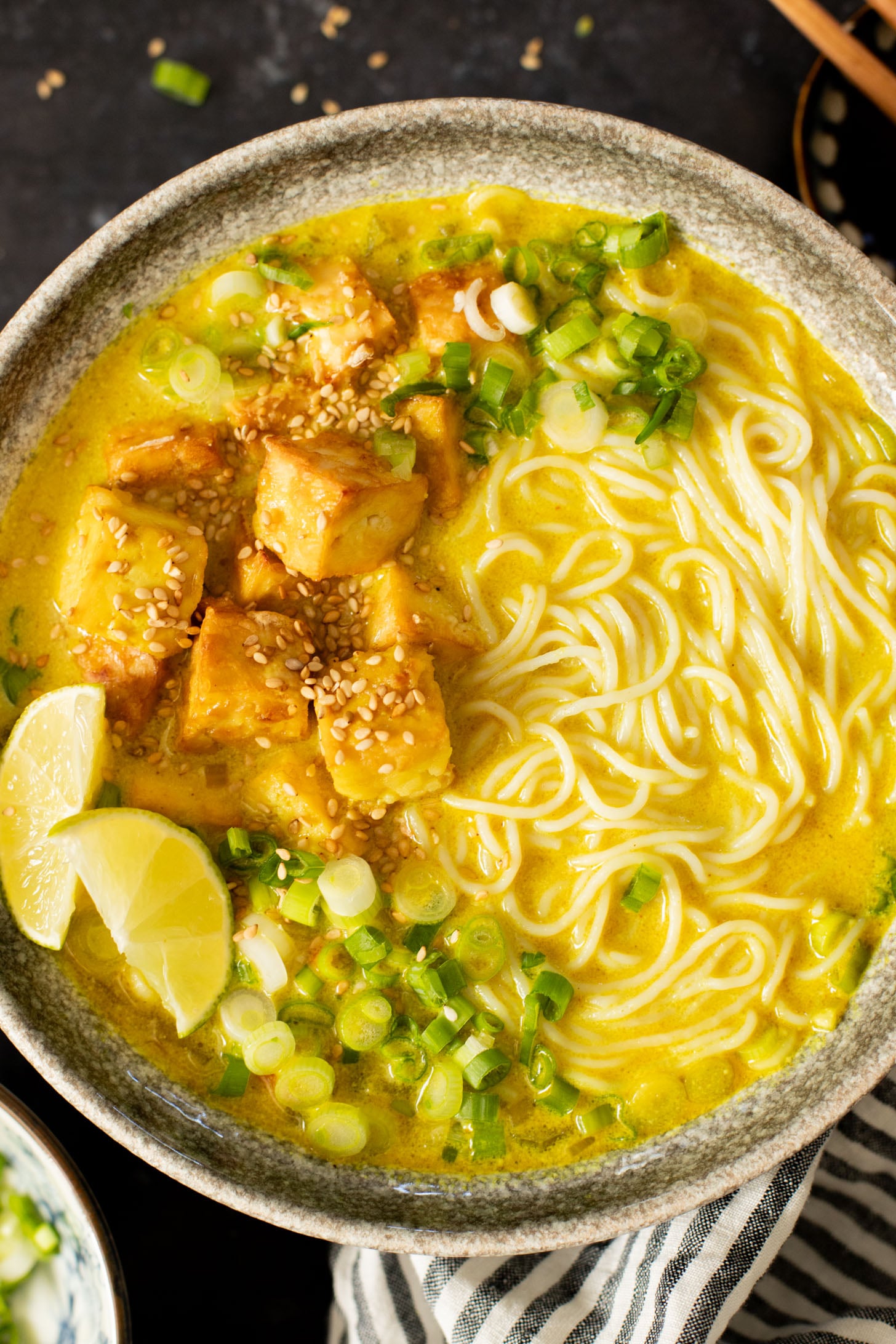 This Golden Coconut Noodle Soup is healthy & heart warming. A coconut curry broth, crispy baked tofu & tender rice noodles | ThisSavoryVegan.com #vegansoup #noodlesoup #healthysoup