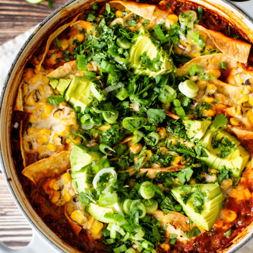 This Black Bean Tortilla Enchilada Rice Bake is a one-pot vegan dinner that is packed with veggies, rice, beans, corn salad and crispy tortillas | ThisSavoryVegan.com #thissavoryvegan #dumpandbake #vegancasserole