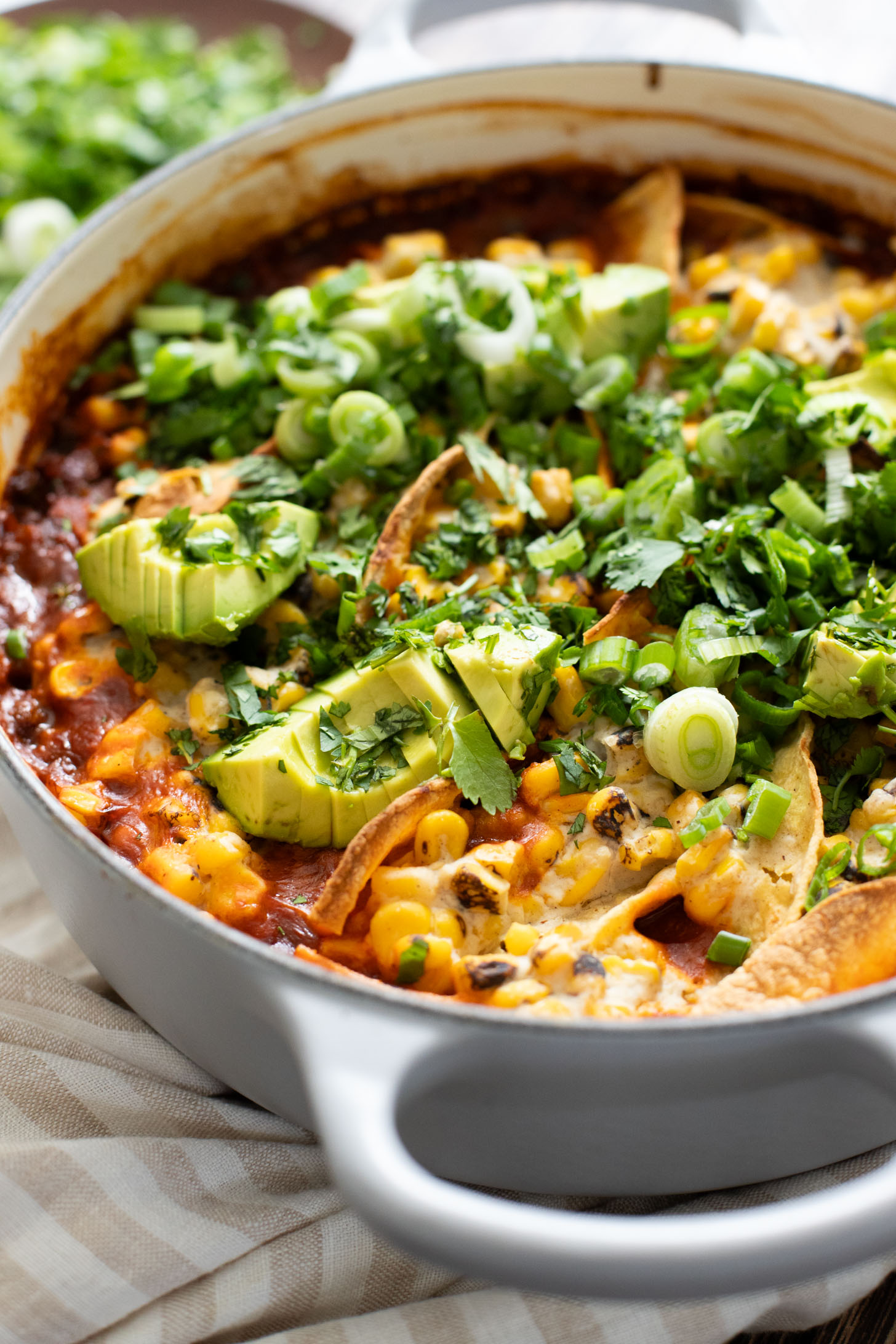 This Black Bean Tortilla Enchilada Rice Bake is a one-pot vegan dinner that is packed with veggies, rice, beans, corn salad and crispy tortillas | ThisSavoryVegan.com #thissavoryvegan #dumpandbake #vegancasserole