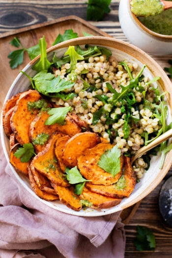 This Chimichurri Couscous & Roasted Sweet Potatoes recipe is healthy, comfort food. Pearl couscous tossed in homemade chimichurri & topped with seasoned sweet potatoes | ThisSavoryVegan.com #thissavoryvegan #couscousrecipes #roastedpotatoes