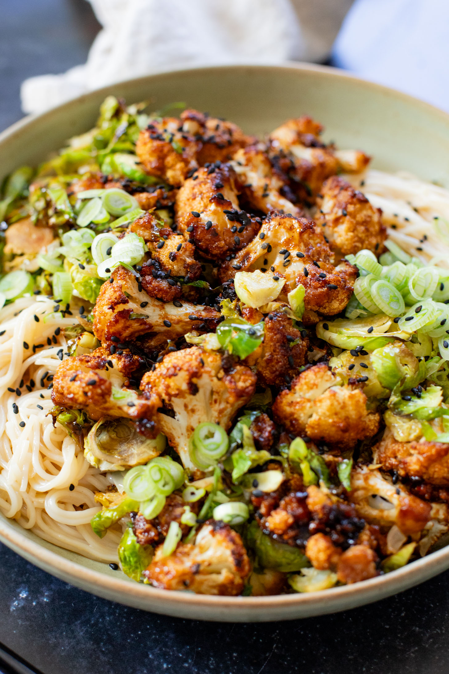 This Hoisin Cauliflower & Coconut Rice Noodles recipe is better than takeout! Coconut rice noodles are topped with crispy cauliflower & roasted brussels sprouts | ThisSavoryVegan.com #thissavoryvegan #cauliflowerrecipes #vegantakeoutrecipes