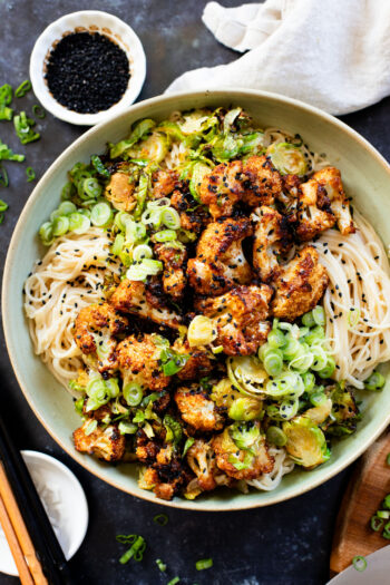 This Hoisin Cauliflower & Coconut Rice Noodles recipe is better than takeout! Coconut rice noodles are topped with crispy cauliflower & roasted brussels sprouts | ThisSavoryVegan.com #thissavoryvegan #cauliflowerrecipes #vegantakeoutrecipes