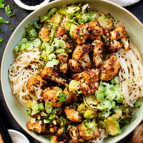 This Hoisin Cauliflower & Coconut Rice Noodles recipe is better than takeout! Coconut rice noodles are topped with crispy cauliflower & roasted brussels sprouts | ThisSavoryVegan.com #thissavoryvegan #cauliflowerrecipes #vegantakeoutrecipes
