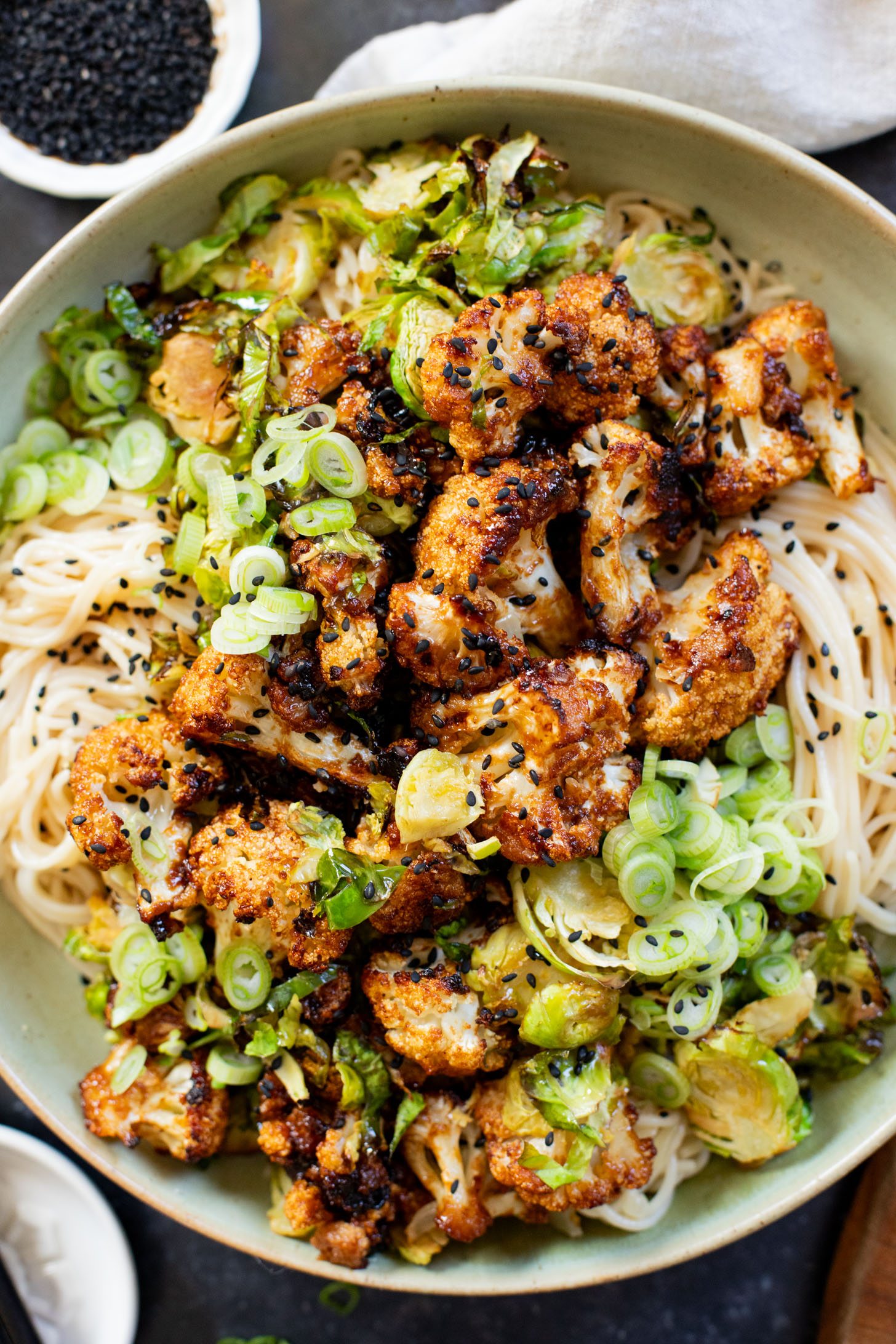 This Hoisin Cauliflower & Coconut Rice Noodles recipe is better than takeout! Coconut rice noodles are topped with crispy cauliflower & roasted brussels sprouts | ThisSavoryVegan.com #thissavoryvegan #cauliflowerrecipes #vegantakeoutrecipes