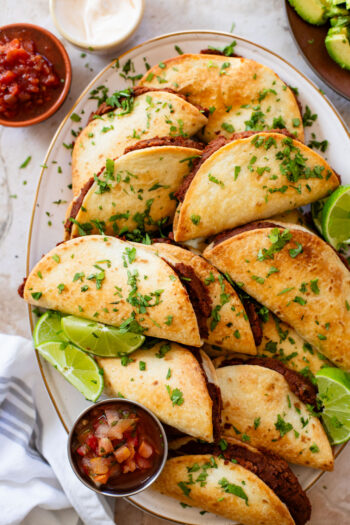 These Mini Refried Bean Tacos are INCREDIBLY simple to make, so tasty and perfect for an easy dinner or game day snack | ThisSavoryVegan.com #thissavoryvegan #vegantacos #gamedaysnacks