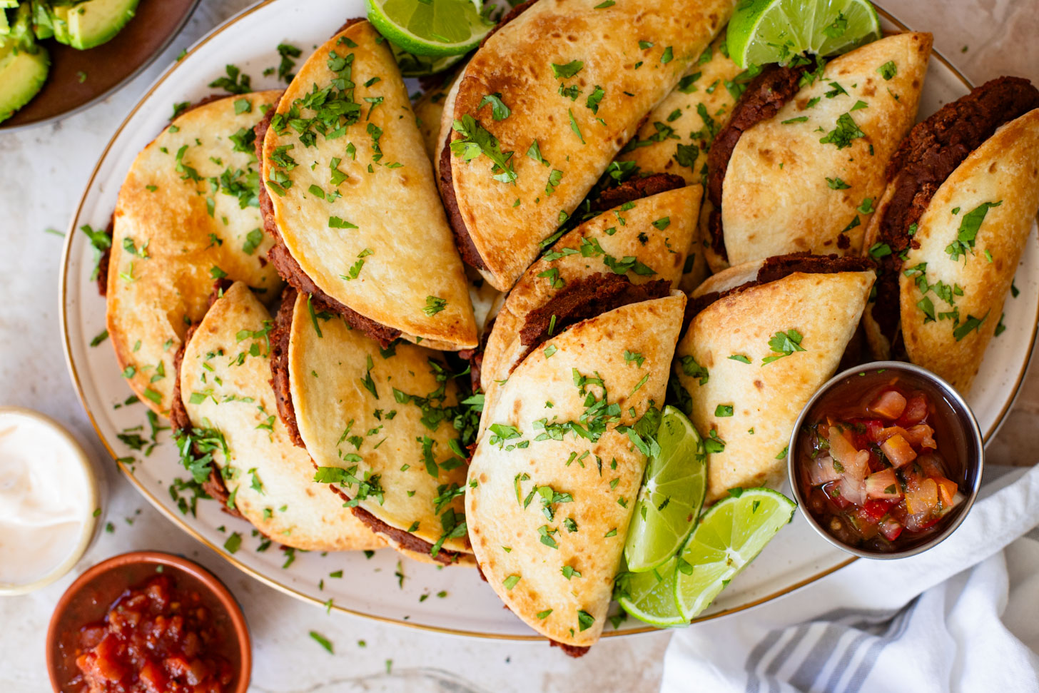 These Mini Refried Bean Tacos are INCREDIBLY simple to make, so tasty and perfect for an easy dinner or game day snack | ThisSavoryVegan.com #thissavoryvegan #vegantacos #gamedaysnacks