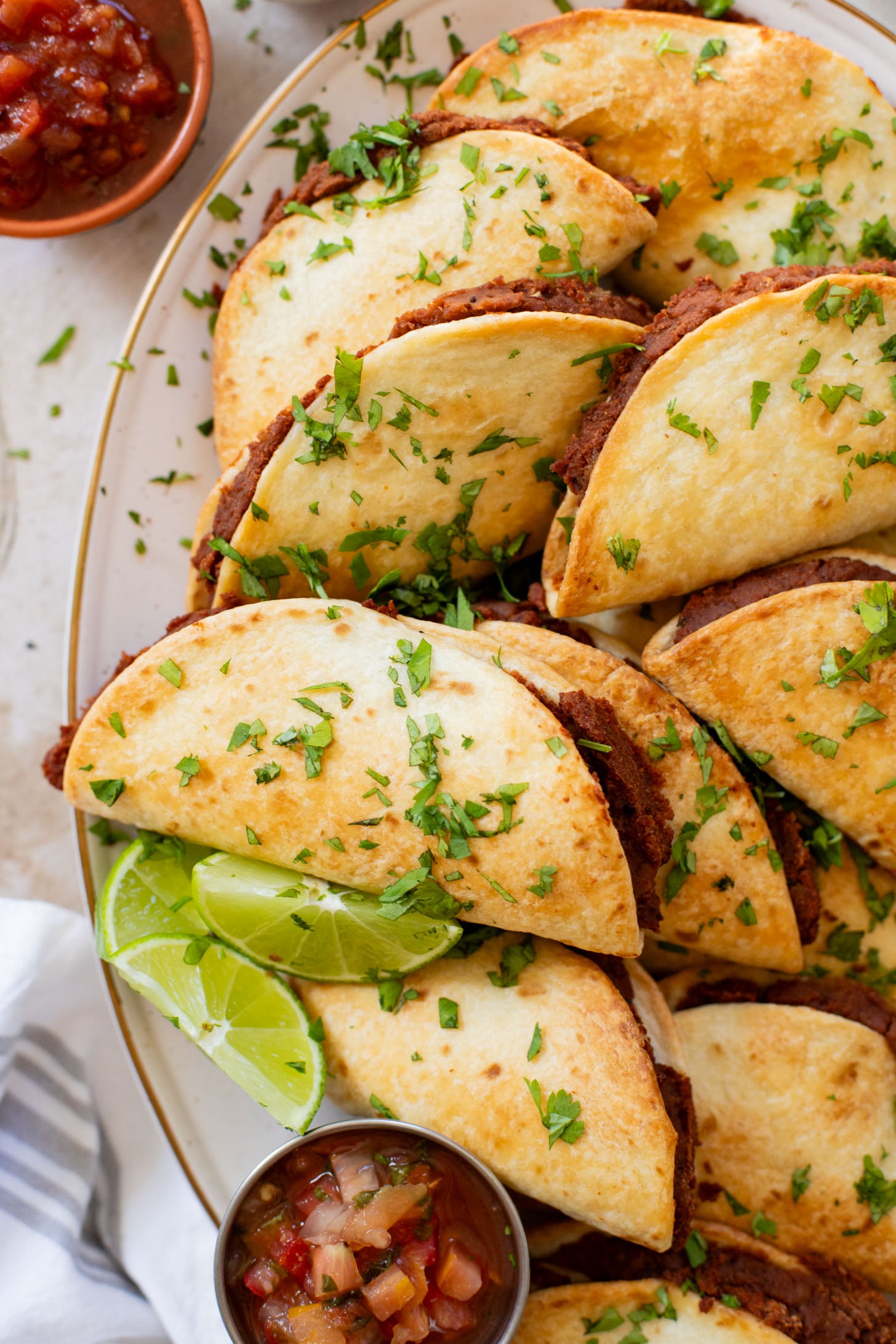 These Mini Refried Bean Tacos are INCREDIBLY simple to make, so tasty and perfect for an easy dinner or game day snack | ThisSavoryVegan.com #thissavoryvegan #vegantacos #gamedaysnacks