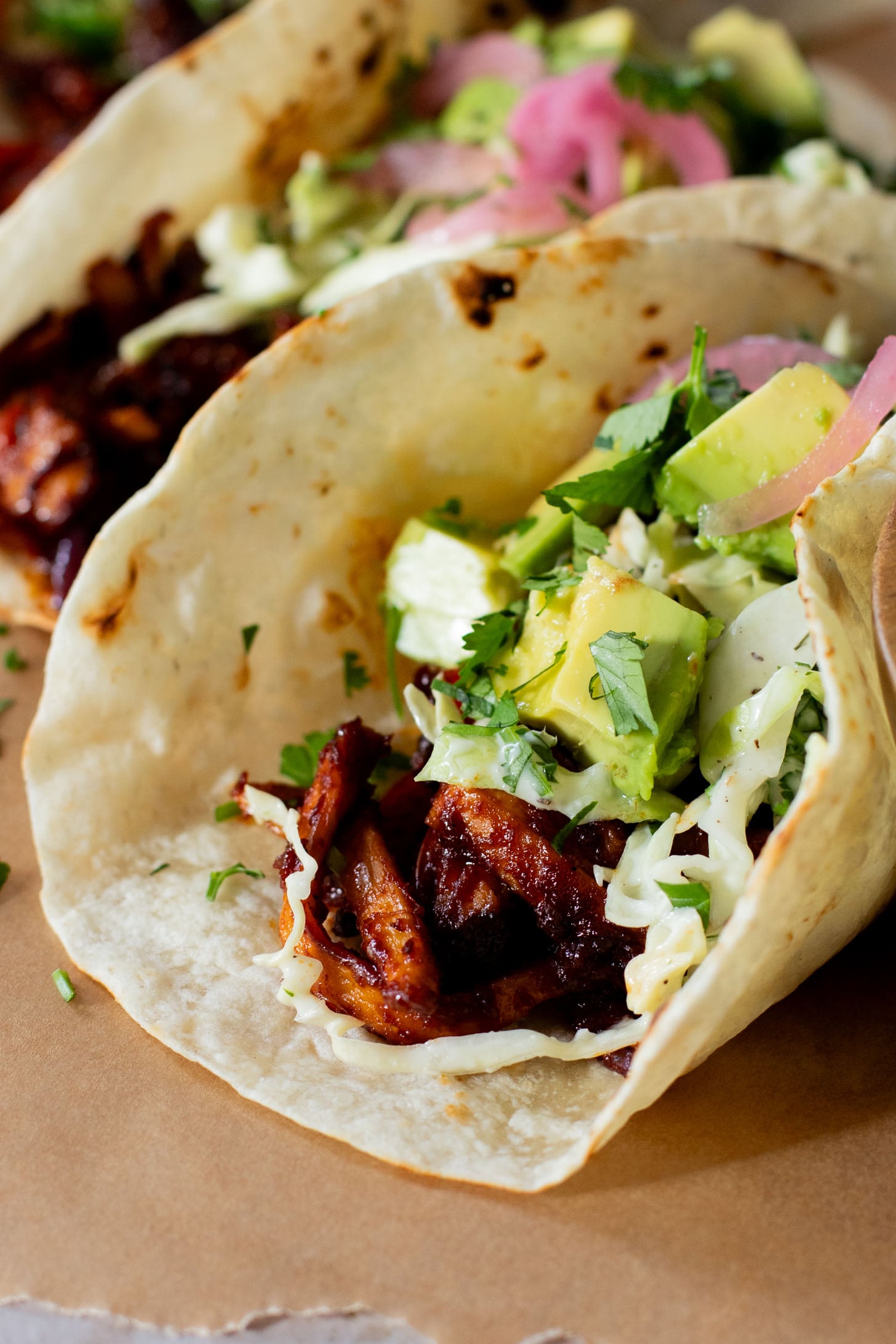 These Oyster Mushroom BBQ Tacos are vegan taco goals! Shredded mushrooms are tossed in BBQ sauce & topped with vegan slaw & avocado | ThisSavoryVegan.com #thissavoryvegan #vegantacos #mushroomtacos