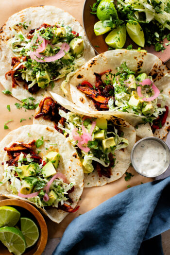These Oyster Mushroom BBQ Tacos are vegan taco goals! Shredded mushrooms are tossed in BBQ sauce & topped with vegan slaw & avocado | ThisSavoryVegan.com #thissavoryvegan #vegantacos #mushroomtacos