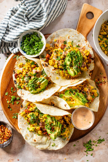 These Tofu Scramble Tacos are layered with seasoned scrambled tofu, soyrizo, pinto beans, avocado and a dairy-free chipotle ranch | ThisSavoryVegan.com #thissavoryvegan #vegantacos #veganbrunchideas
