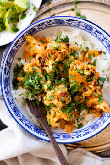 This Roasted Red Curry Cauliflower is a simple & delicious veggie dish. Cauliflower is tossed in a red curry coconut sauce & roasted. Serve with rice | ThisSavoryVegan.com #thissavoryvegan #cauliflowerrecipes #veggierecipes